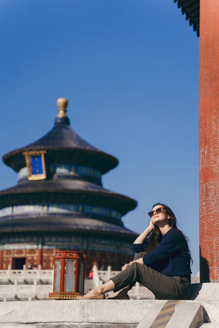 Una mujer posando en beijing-viaje, de fondo un edificio antiguo.